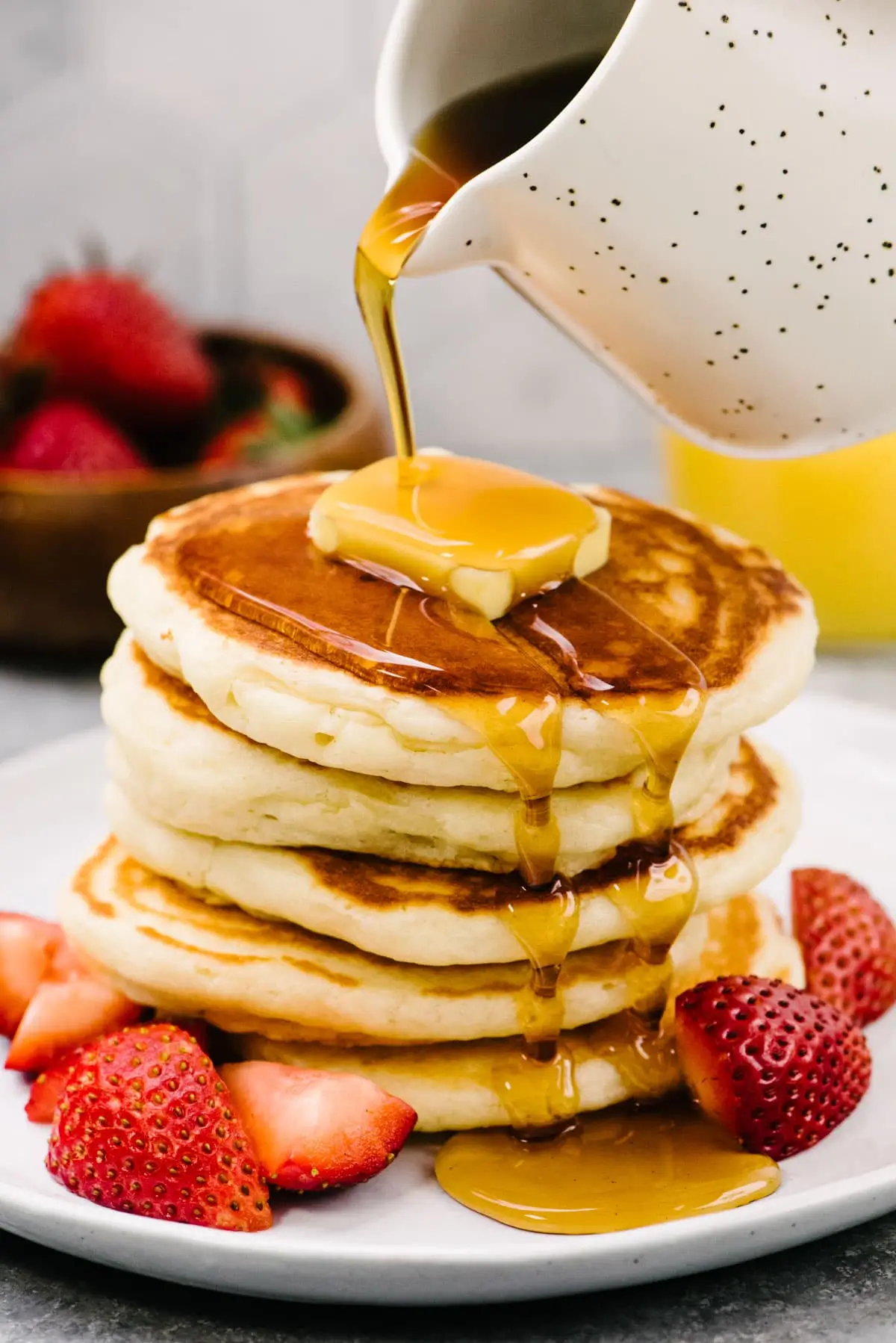 Stack of fluffy golden homemade pancakes with syrup